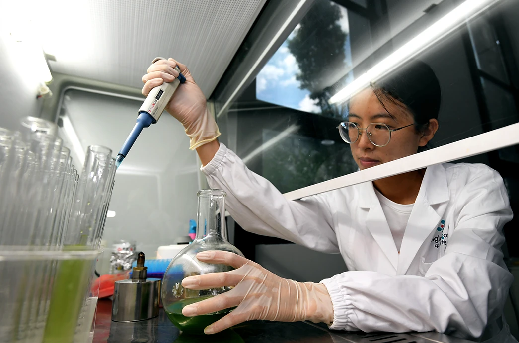 A technician inoculates microalgae cells at a biological laboratory in Guiyang, China. (CFOTO/Future Publishing via Getty Images)